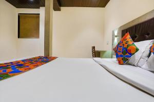 1 dormitorio con 1 cama blanca grande con almohadas coloridas en FabHotel New Prince Palace en Bombay