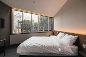 Postel nebo postele na pokoji v ubytování Pillowsopher Hongdae