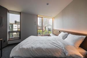 Postel nebo postele na pokoji v ubytování Pillowsopher Hongdae