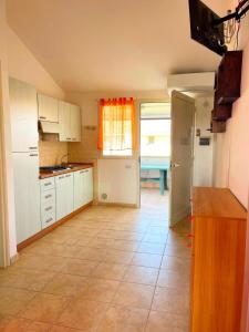 a kitchen with white cabinets and a tile floor at Lianna Beach Resort in Marina di Montenero