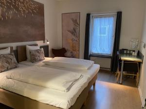 um quarto de hotel com duas camas e uma janela em City Hotel Nattergalen em Odense