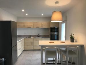 a kitchen with a table and some chairs in it at Appartement neuf avec Spa in Saint-Martin-dʼArdèche