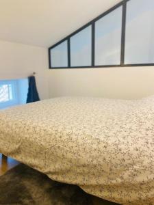 a bed in a room with two windows at Appartement neuf avec Spa in Saint-Martin-dʼArdèche