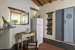 een keuken met een witte koelkast en een tafel bij Un gioiello in centro storico in Bari Sardo
