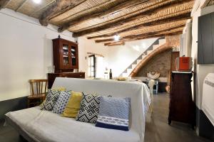een woonkamer met een bank met kussens erop bij Un gioiello in centro storico in Bari Sardo