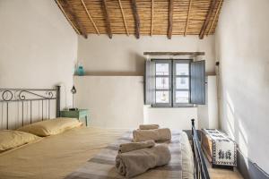 een slaapkamer met een bed met 2 kussens erop bij Un gioiello in centro storico in Bari Sardo