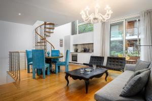 uma sala de estar com uma mesa e cadeiras azuis em Business & Luxury Suite - Montè16 em Milão