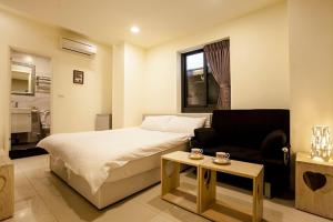 a bedroom with a bed and a couch and a table at Biau Tsan Su in Taichung