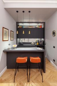 eine Küche mit zwei orangenen Stühlen an der Theke in der Unterkunft Migliori Collection Piazza Navona 71 in Rom