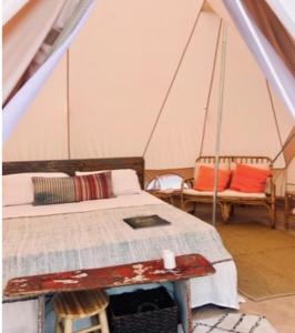 ein Schlafzimmer mit einem Bett und zwei Stühlen in einem Zelt in der Unterkunft Il Mulino dei Veraghi The Mill at the Falls in Molina