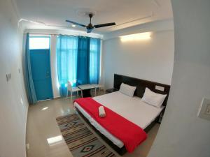 um quarto com uma cama com um cobertor vermelho em LA SIESTA INDIA MCLEODGANJ em McLeod Ganj