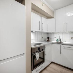 a white kitchen with white cabinets and an oven at Holmboe Apartment in Bergen