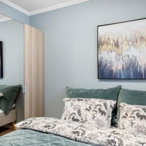 a bedroom with a bed and a painting on the wall at Holmboe Apartment in Bergen