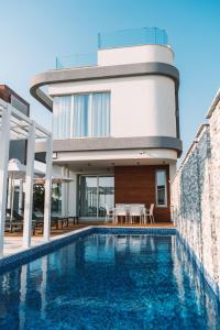 a house with a swimming pool in front of a house at Napa Hills Seaview Villas in Ayia Napa