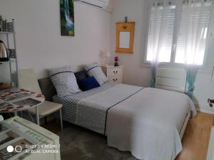 1 dormitorio con cama y sofá en CHAMBRE CONFORTABLE,Près Gare,CLIM,PARKING,pt déjeuner, en Perpiñán