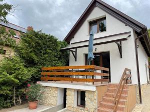 a house with a balcony with a blue umbrella on it at Green Valley Vendégház a Betekints-völgyben in Veszprém