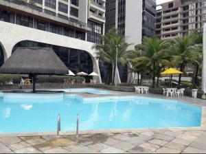 a large swimming pool with tables and umbrellas at hotel gold beach in Recife