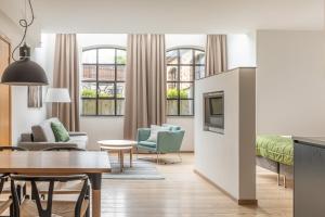 a living room with a couch and a tv and a table at The More Hotel Lund in Lund