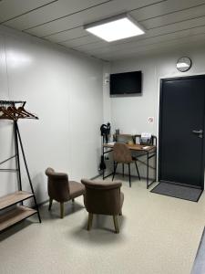 a room with a table and chairs and a black door at Les Chambres de Campagne in Campagne