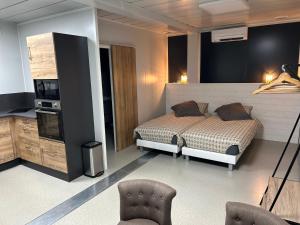 a bedroom with a bed and two chairs in it at Les Chambres de Campagne in Campagne