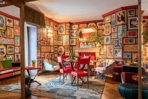 a dining room with a table and chairs and a wall of paintings at Ambra Cortina Luxury&Fashion Hotel in Cortina dʼAmpezzo