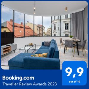 - un canapé bleu dans le salon doté d'une grande fenêtre dans l'établissement Apartament Prestige Centrum, à Bielsko-Biała