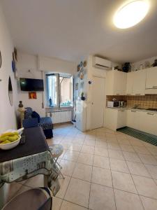 cocina y sala de estar con mesa y habitación en Monolocale IL GRIFO, en Albisola Superiore
