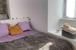 - un lit avec des oreillers violet et orange dans l'établissement Appartement avec chambre ouverte, à Bourg-Madame