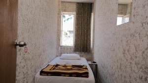 アンタルヤにあるAziz Pansiyon 3のベッドと窓が備わる小さな客室です。