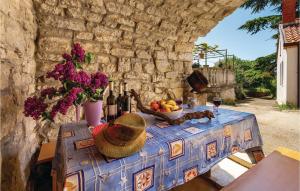 Beautiful Home In Kastav With Kitchen في كاستاف: طاولة مع وعاء من الفواكه وزجاجات النبيذ