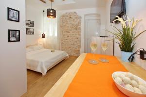 a bedroom with a bed and two wine glasses on a table at Guverna New City Accommodation in Zadar