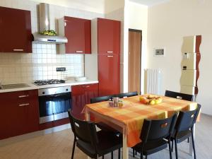 a kitchen with a table with chairs and red cabinets at Case Vacanze Carpe Diem Gallipoli in Gallipoli