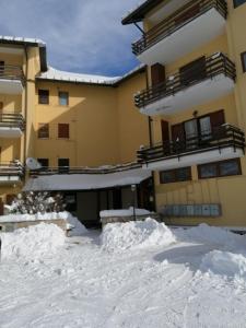 um edifício com neve em frente em Elle house Mansarda em Rocca di Cambio