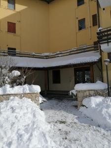 una casa cubierta de nieve con techo en Elle house Mansarda, en Rocca di Cambio