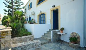 una casa blanca con una puerta azul y escaleras en Logothetianika houses - Kithikies holiday houses, en Kámbos