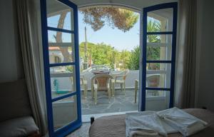 1 dormitorio con puerta que da a un patio con mesa en Logothetianika houses - Kithikies holiday houses, en Kámbos