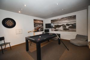 een woonkamer met een pooltafel en een bank bij Hotel Louisa in Oostende