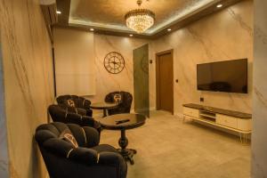 ein Zimmer mit Stühlen, einem Fernseher und einem Tisch in der Unterkunft ALEE BEYZAR Hotel in Ankara