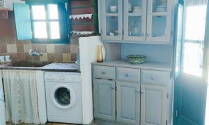 uma cozinha com uma máquina de lavar roupa e armários azuis em PATELO HOUSE em Agia Marina