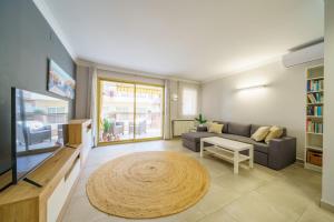 - un salon avec un canapé et une télévision dans l'établissement HomeHolidaysRentals Liberty - Costa Barcelona, à Pineda de Mar