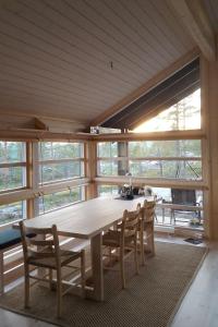 a table and chairs in a room with a large window at Myrullen - Cabin at Sørbølfjellet in Flå