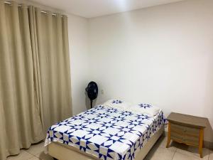 a bedroom with a bed and a table in it at Ap barato e perfeito insta thiagojacomo in Goiânia