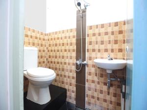 a bathroom with a toilet and a sink at OYO 2595 Lumungga Residence Syariah in Bandar Lampung