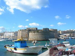 a boat in the water in front of a castle at Case Vacanze Carpe Diem Gallipoli in Gallipoli