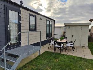 eine Terrasse mit einem Tisch und Stühlen sowie ein Haus in der Unterkunft Stacaravan De Maravan in Middelkerke