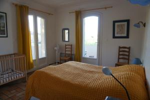 ein Schlafzimmer mit einem Bett und zwei Fenstern in der Unterkunft Villa in Isle sur la Sorgue in LʼIsle-sur-la-Sorgue