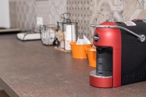 a red and black appliance sitting on top of a counter at Diegohousesleepaway in Vittoria