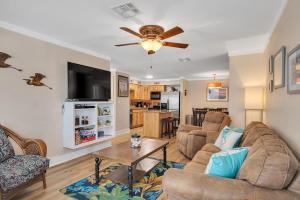sala de estar con sofá y mesa en Smiling Jacks Escape Condominium, en Mustang Beach
