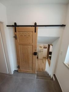 una grande porta in legno in un corridoio con scale di Rösslerhof Ferienwohnung Nachtweide 