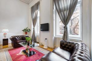 a living room with leather furniture and a window at Royale Apartment in Budapest